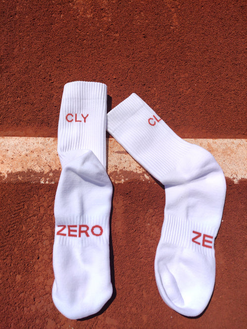 Calcetines de tenis CLY ZERO blancos sobre una pista de tierra batida