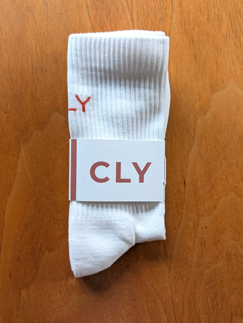 Par de calcetines CLY ZERO con su faja de marca, sobre fondo de madera